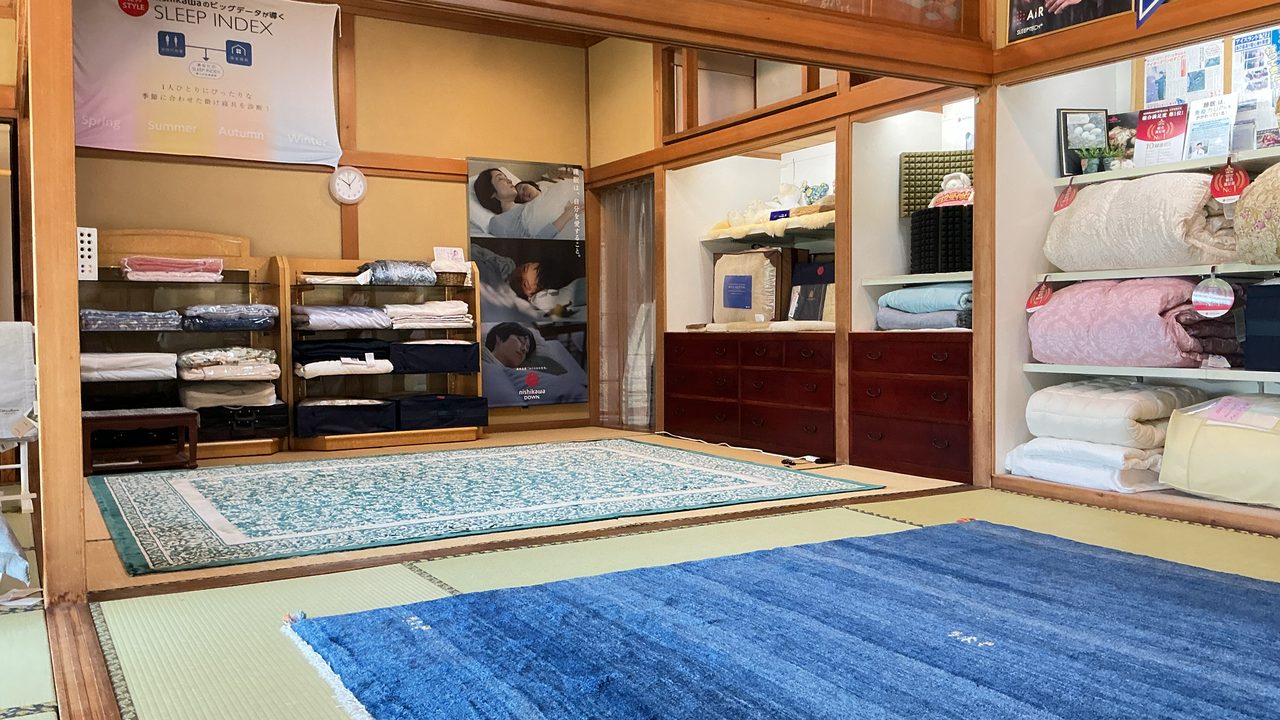 羽毛布団・カバー・タオルケットが並ぶ和室の寝具売り場