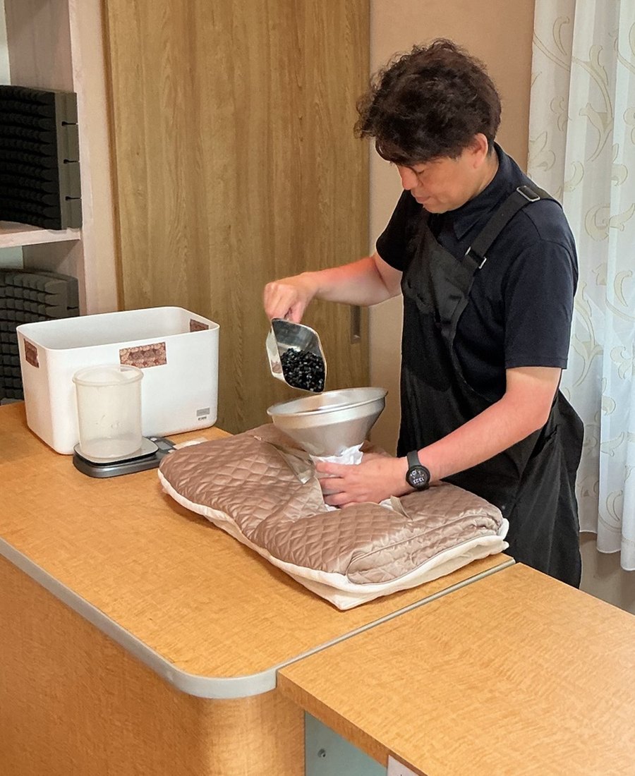 店主が枕に中材を足して高さを合わせている