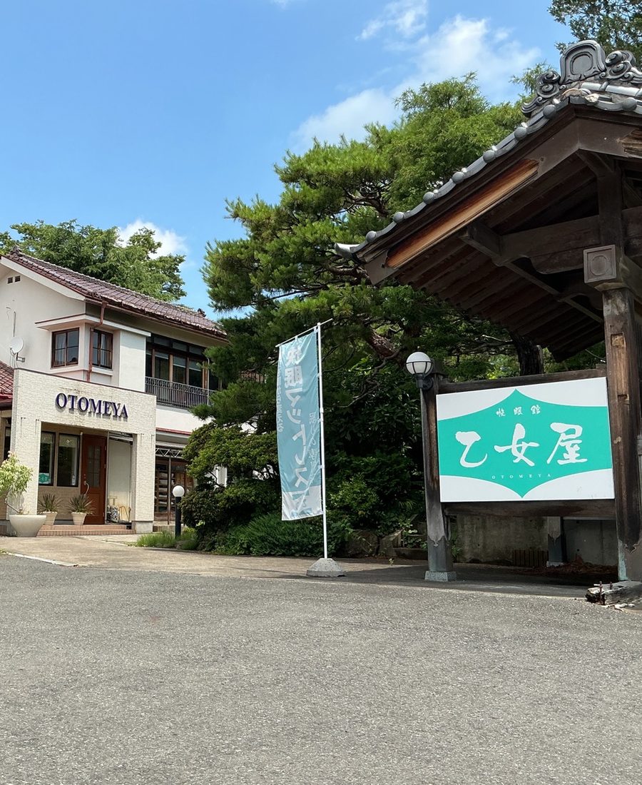 門と庭木のある乙女屋の外観