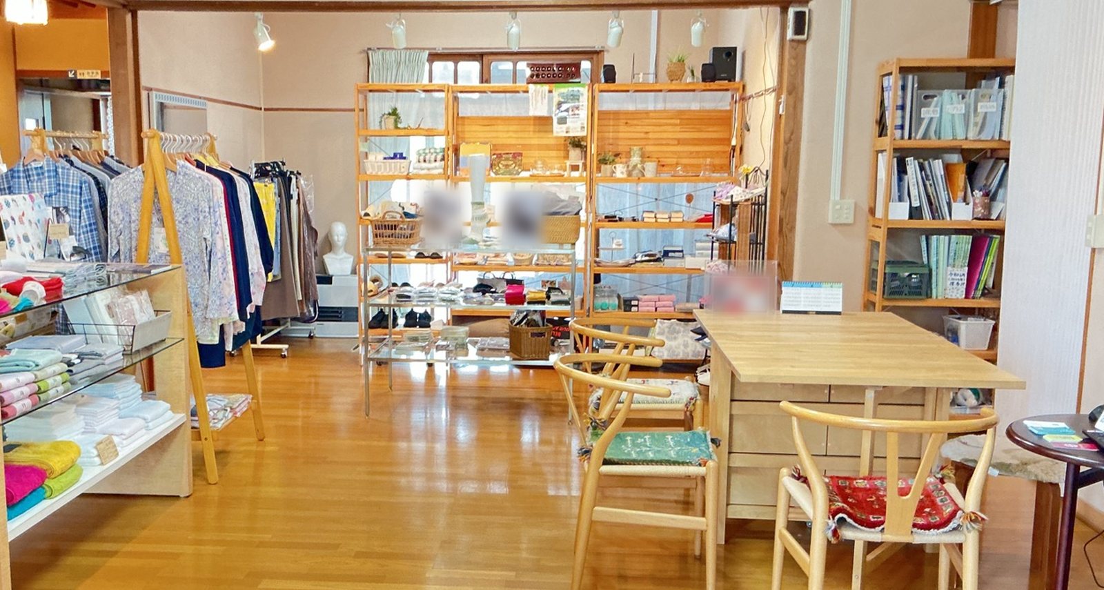 木の床とテーブルのある、明るい洋間の売り場